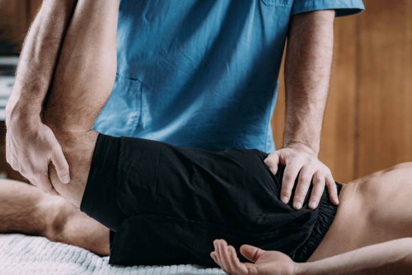 A man undergoing physical therapy with a sports massage, aimed at alleviating muscle tension and enhancing recovery.