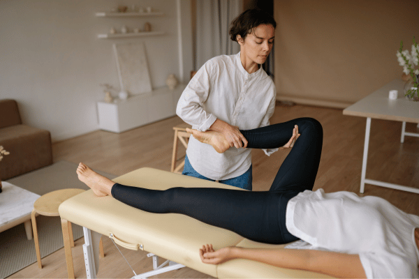 A woman receiving a Thai table massage in a serene room, surrounded by calming decor and soft lighting.
